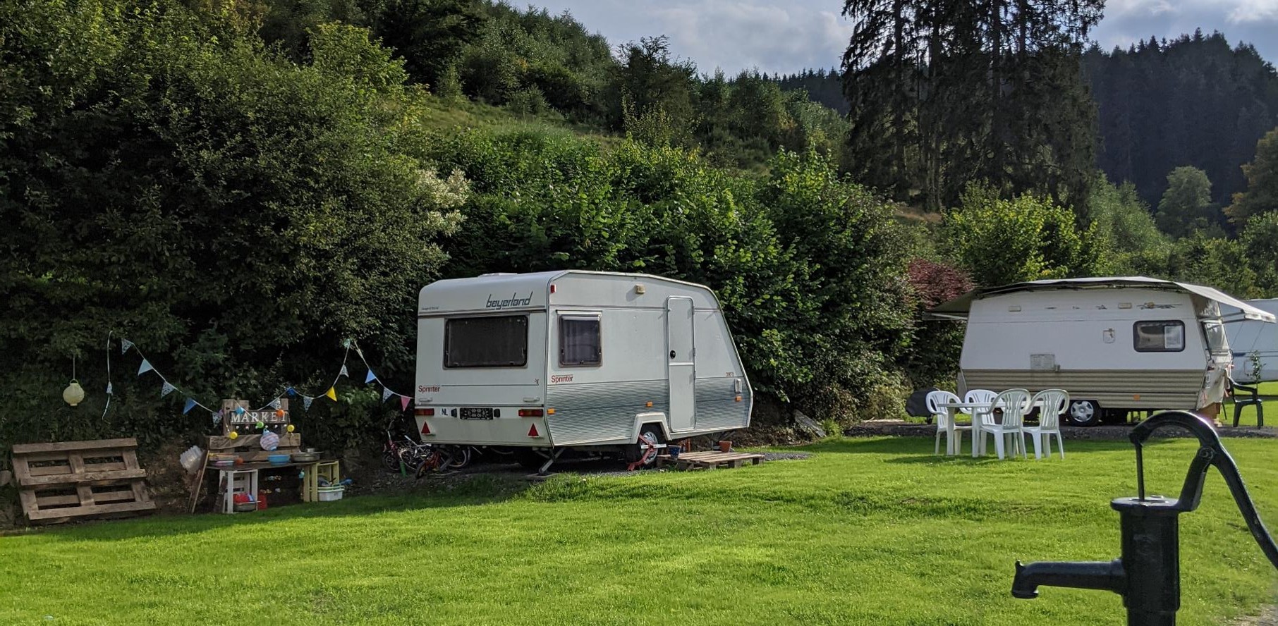 Wohnwagen zwischen Bäumen